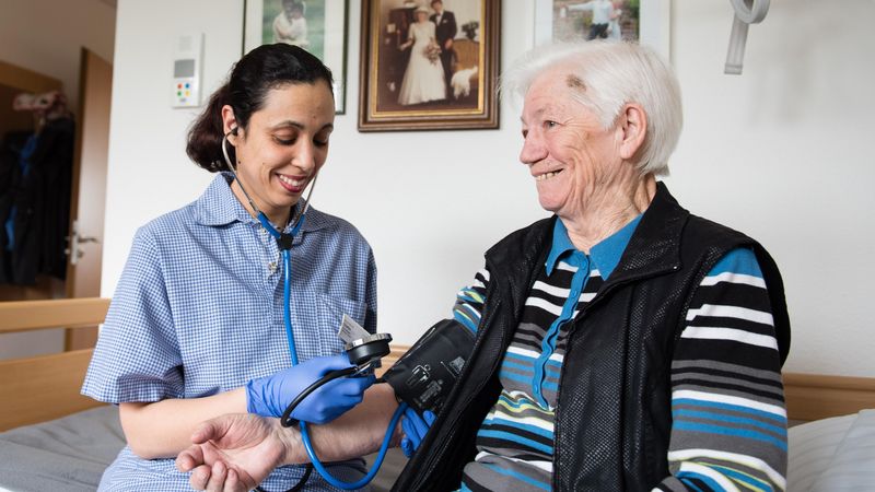 Pflegerin misst Blutdruck bei Bewohnerin