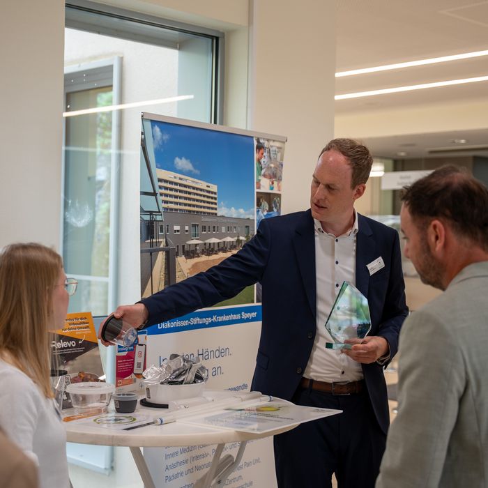 Geschäftsführer erläutert Auslage am Stand 