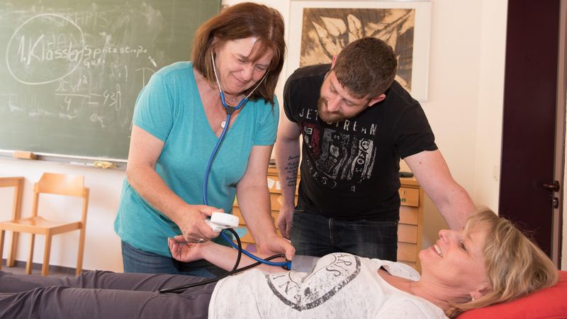 Altenpflegeschüler üben Blutdruckmessen