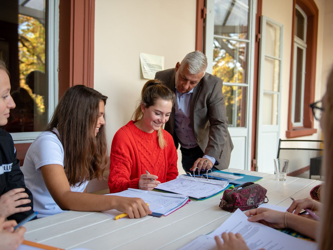 Schülerinnen und Schüler beim Lernen auf der Terasse