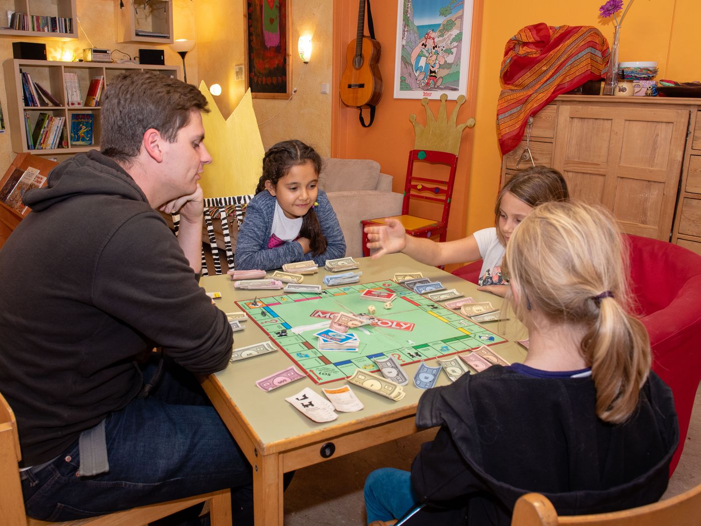 Erzieher und Kinder beim Monopoly spielen