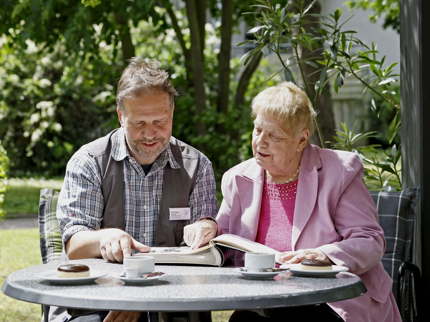 Alltagsbetreuer mit Bewohnerin im Garten