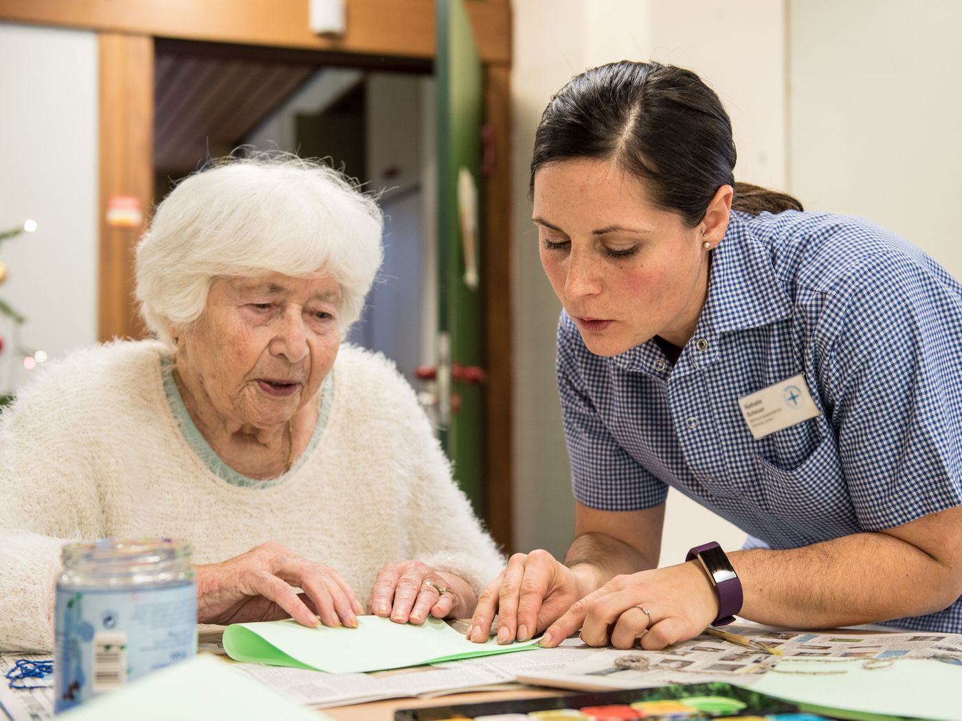 Seniorin und Betreuerin basteln gemeinsam