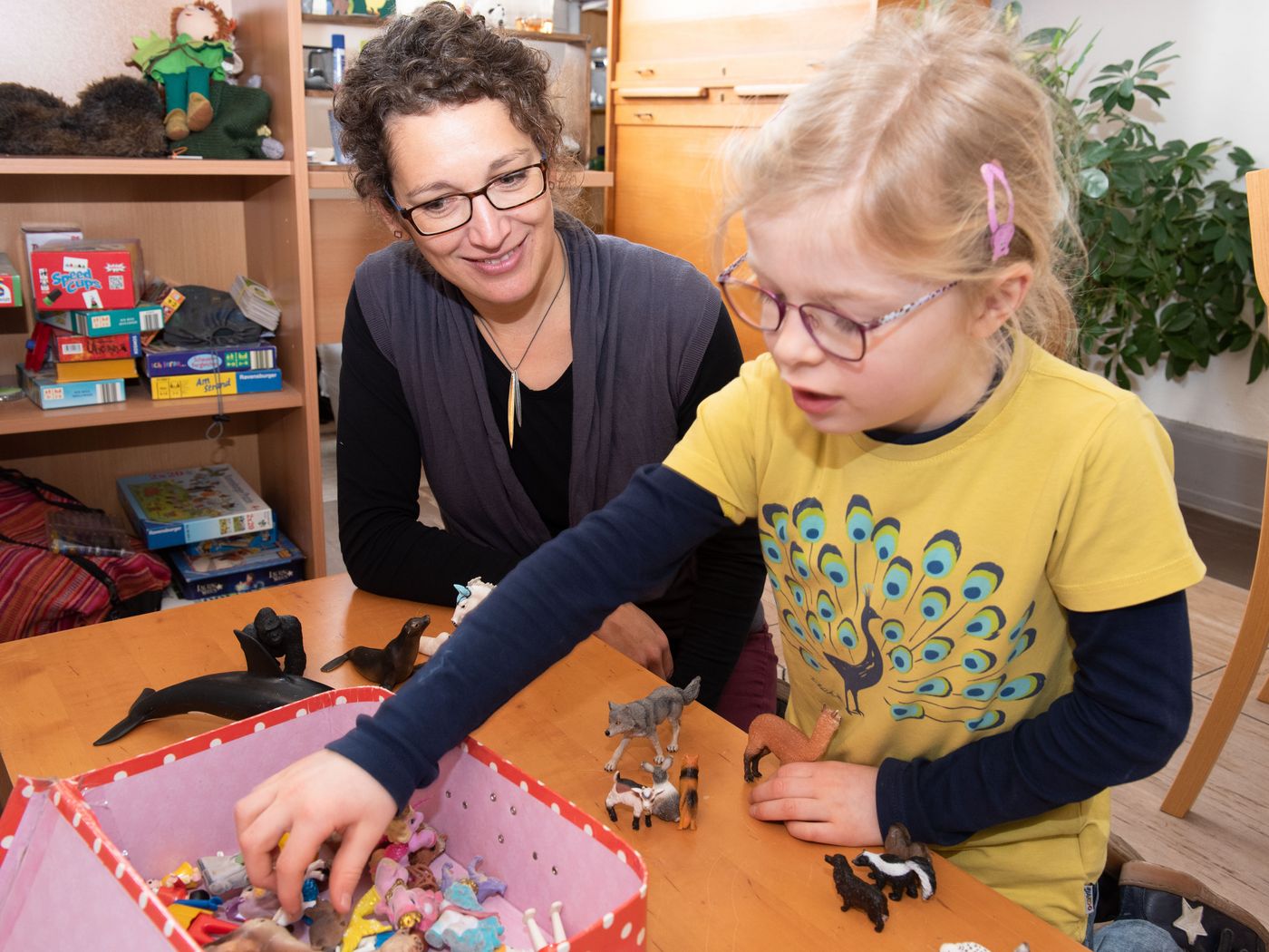 Sozialarbeiterin und Mädchen spielen mit tieren