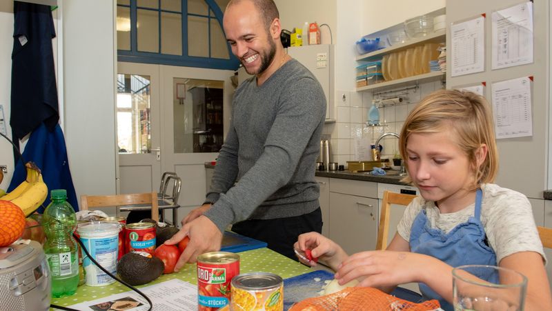 Erzieher und Junge beim Kochen