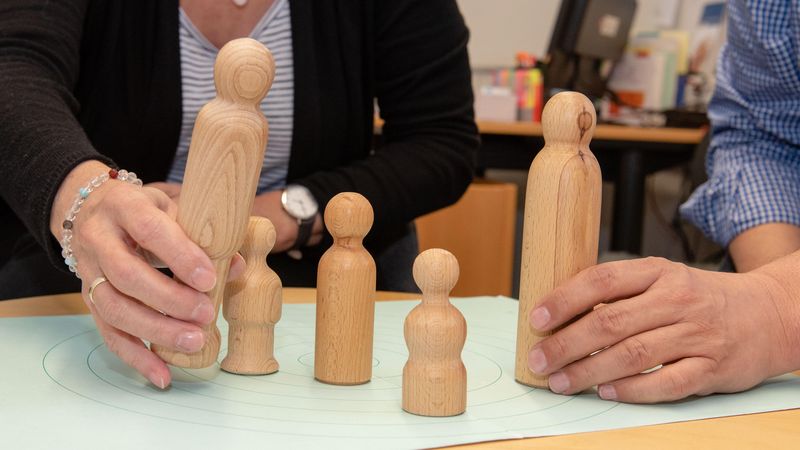 Paar stellt Holzfiguren auf Tisch