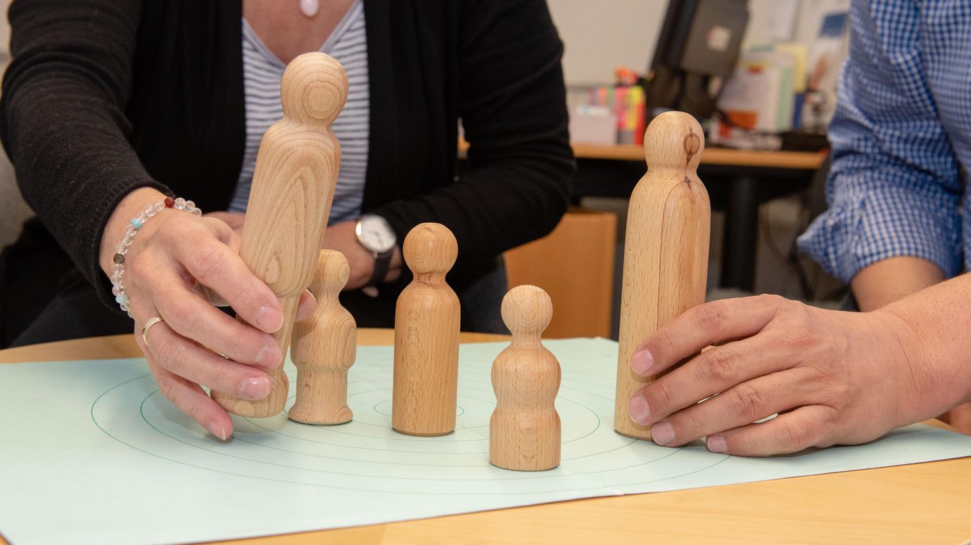 Paar stellt Holzfiguren auf Tisch