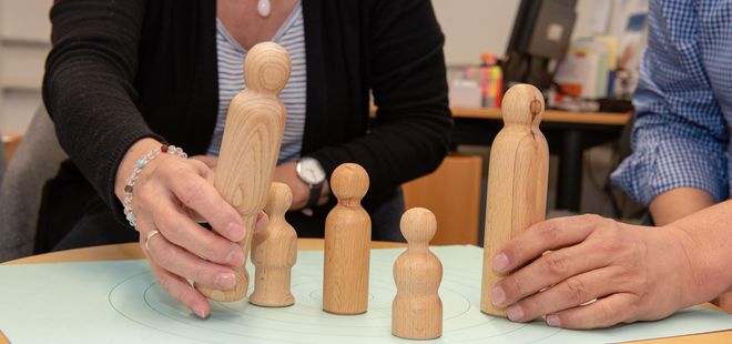 Paar stellt Holzfiguren auf Tisch