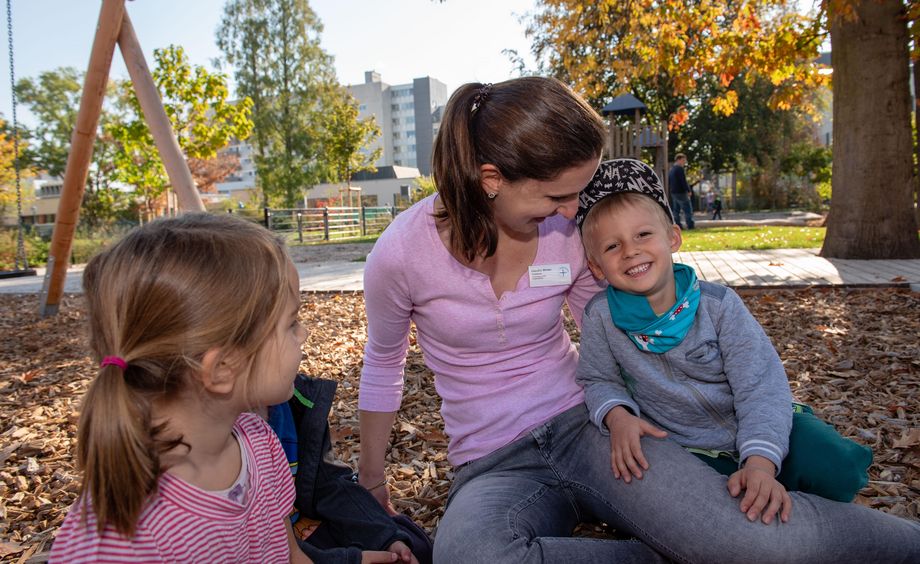 Erzieherin mit Kindern auf dem Spielplatz