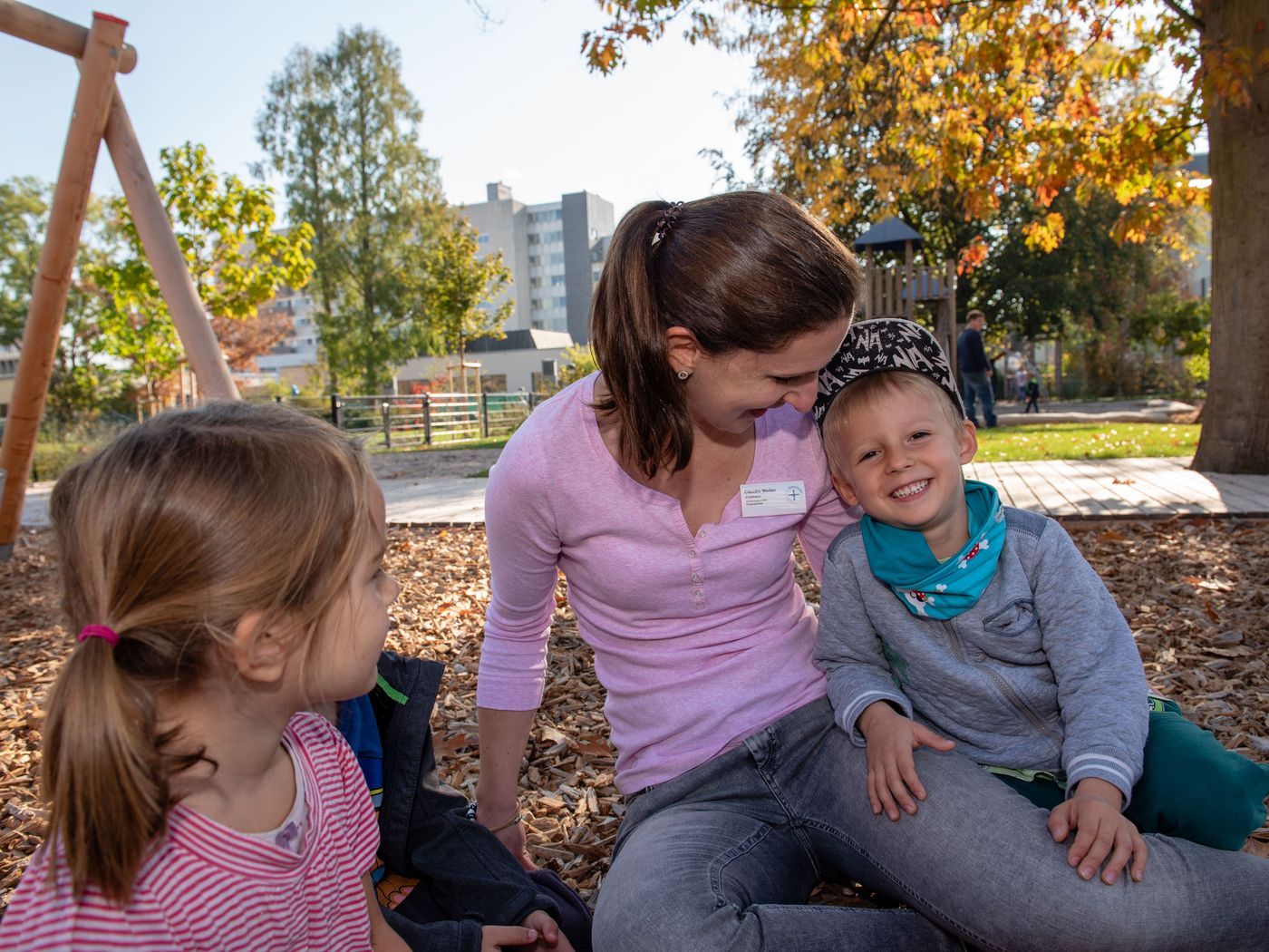 Erzieherin mit Kindern auf dem Spielplatz