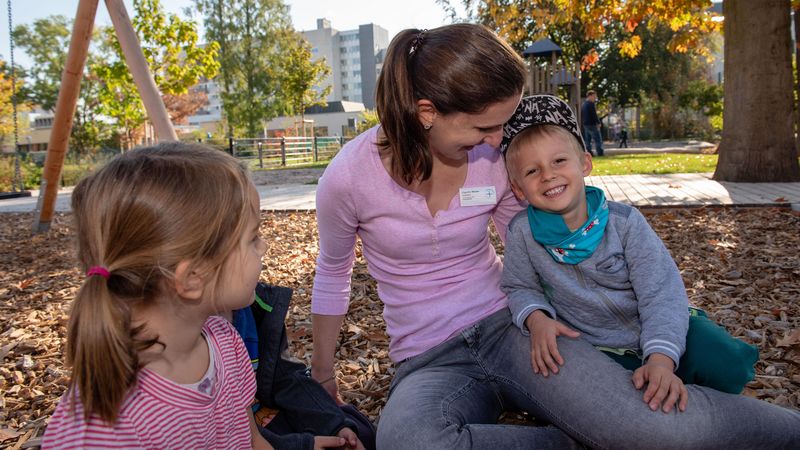 Erzieherin mit Kindern auf dem Spielplatz