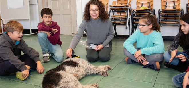 Kinder und Sozialarbeiterin sitzen im Kreis