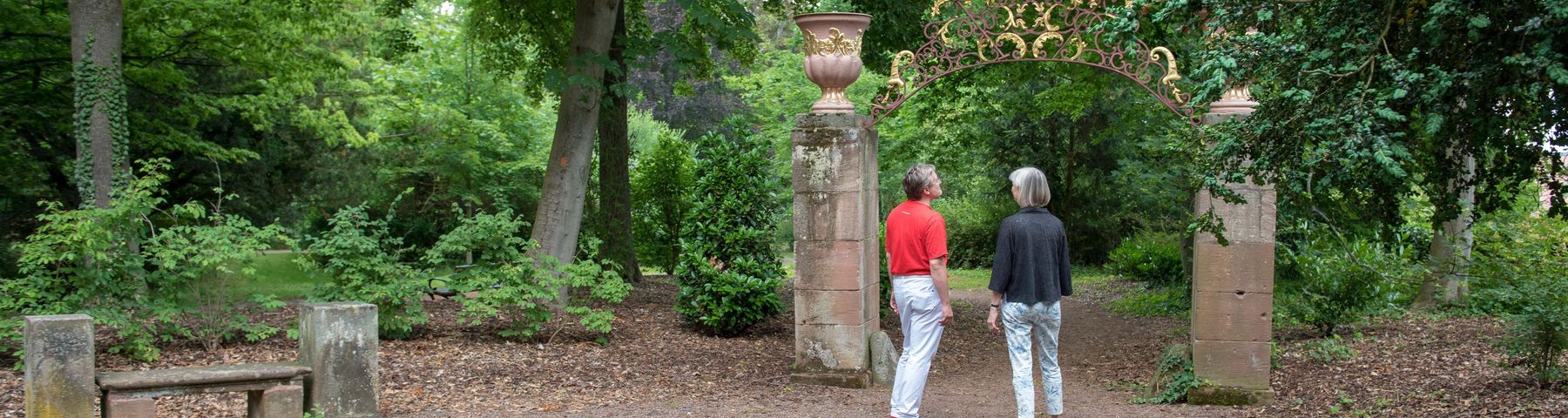 Zwei Menschen vor einem Torbogen im Wald